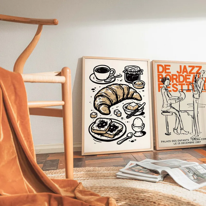 A framed coffee and croissant print in a calm room corner
